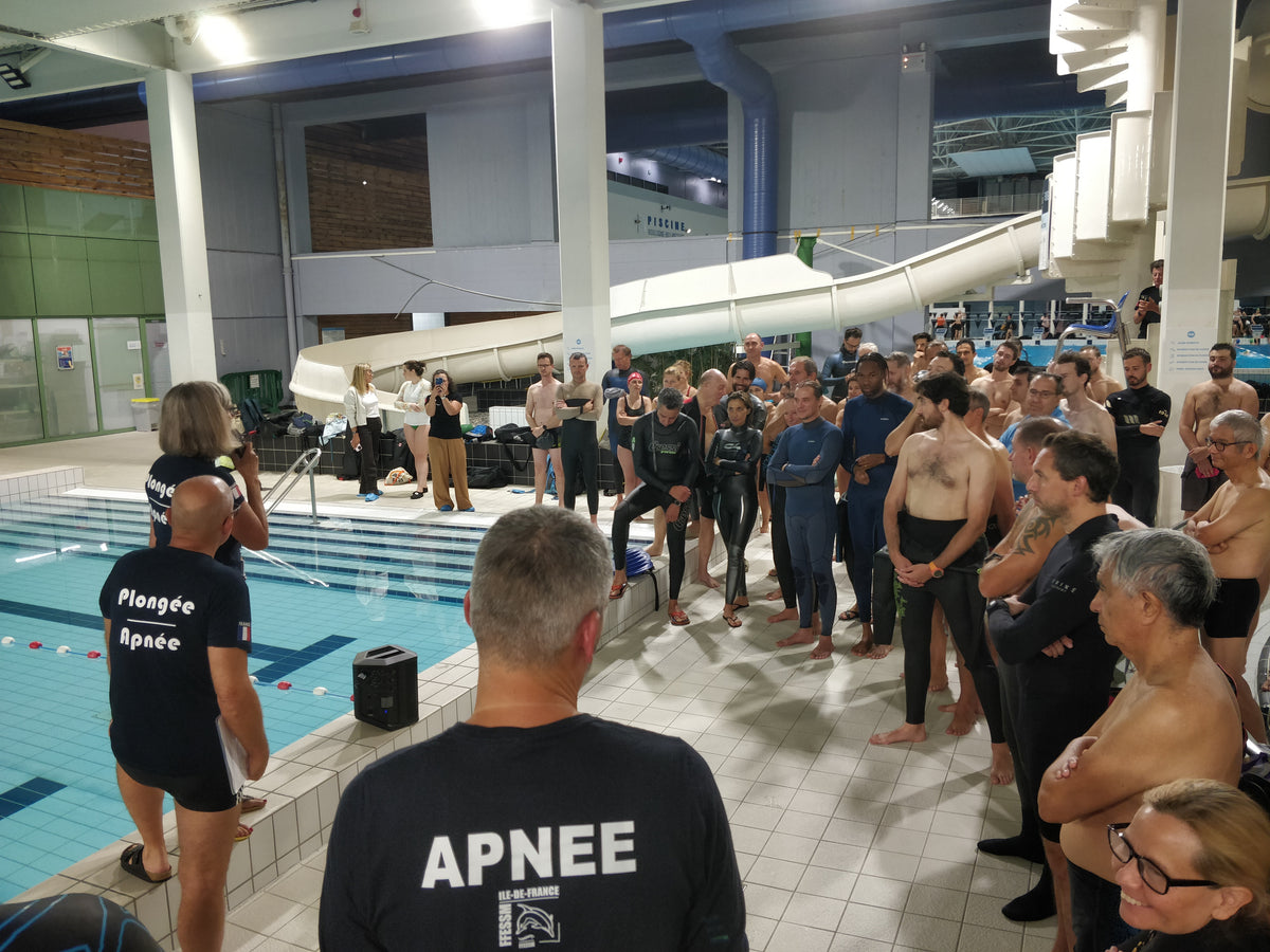 Freediving club members gathered around an instructor by a pool